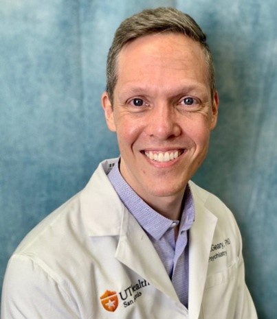 Don McGeary, Ph.D., ABPP, psychologist, in a professional headshot wearing a white coat over a light purple shirt.