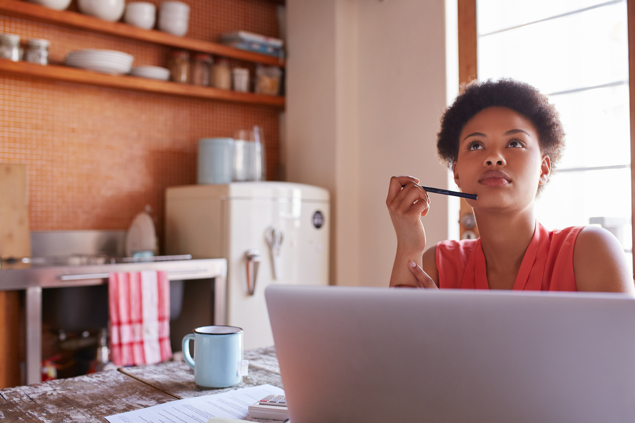 Business begins with an idea Shot of a young woman working on a laptop in her kitchen